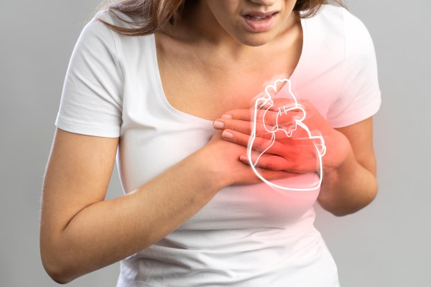 a woman is holding her chest with a heart drawn on her chest