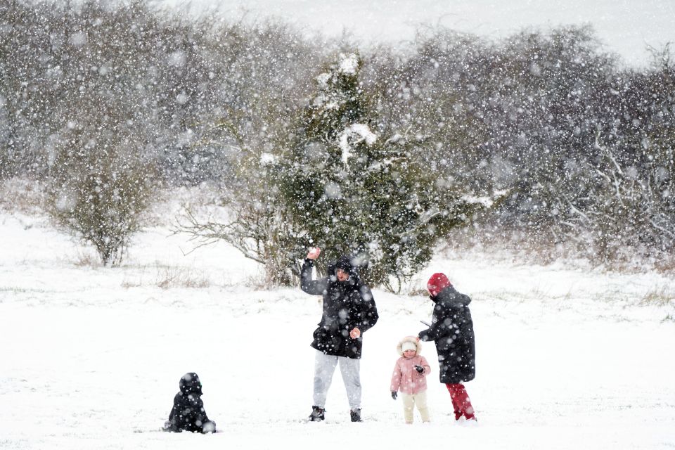 A family plays in the snow on the Dunstable Downs in Bedfordshire