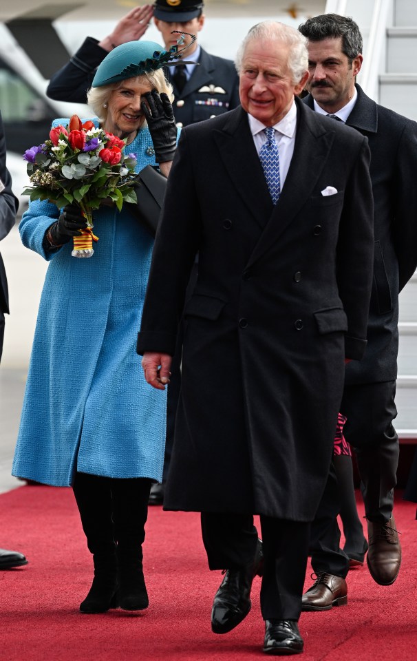 Camilla was handed a bright bouquet of flowers as she donned a blue coat and black boots