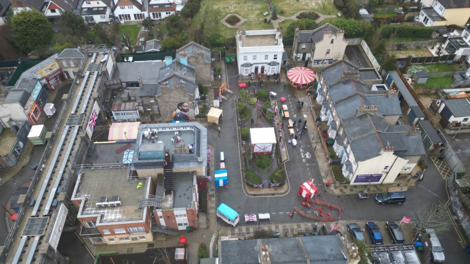 The set has been decorated in bunting, while a fairground ride and ice cream van are also visible