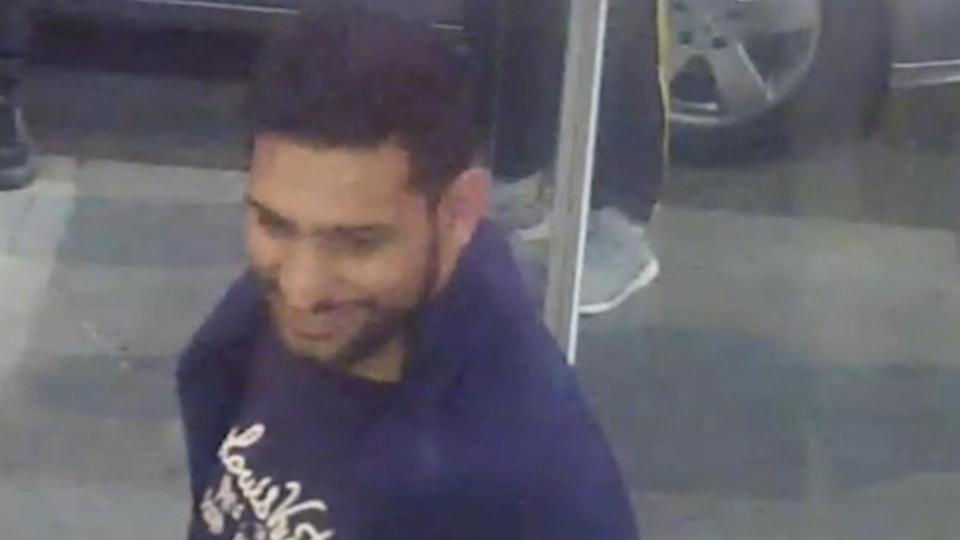 Khan can be seen smiling as he leaves the restaurant moments before the robbery