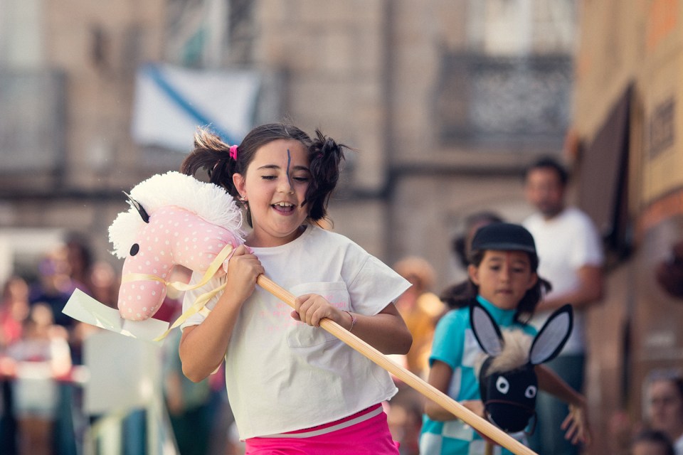 Children take part in hobby horse races