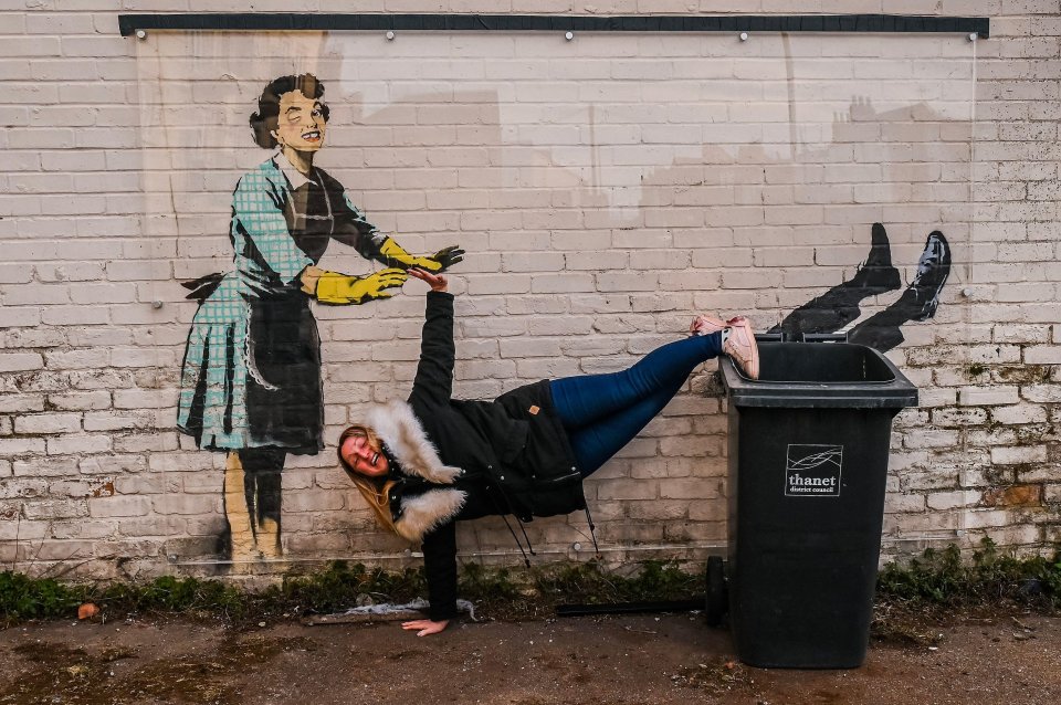 A resident posing with the mural before it was removed