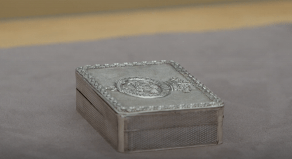 Camilla brought in a snuff box made of English silver