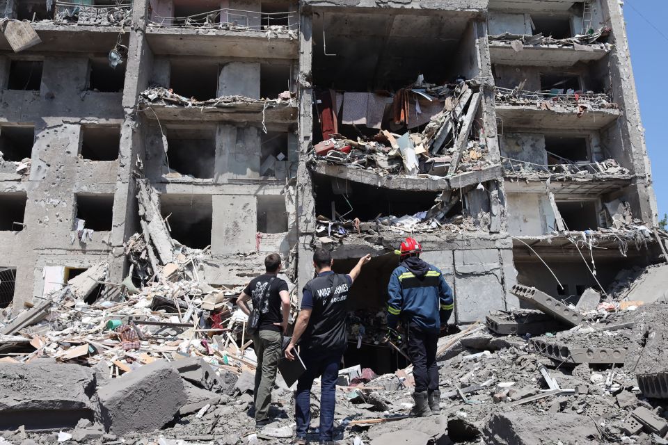 A war crimes prosecutor examines a destroyed building in Sergiyvka, near Odessa