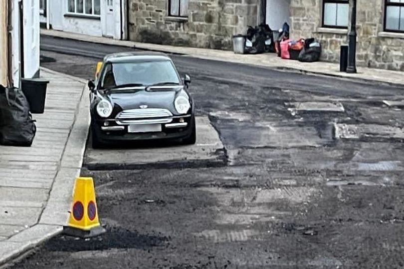 A car could be seen surrounded by fresh tarmac