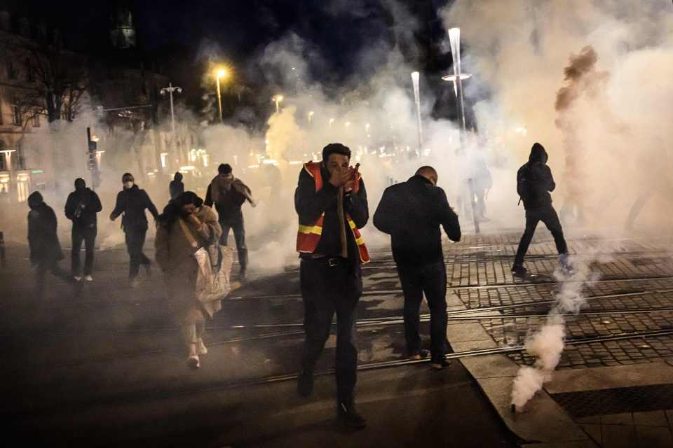 Pedestrians running to avoid tear gas in Nantes