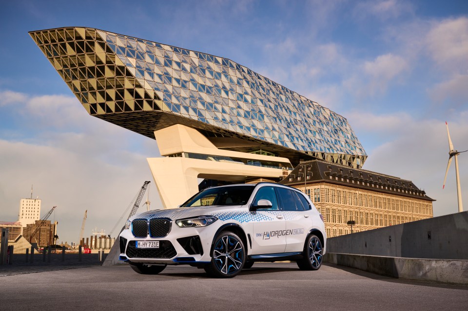 a bmw x5 is parked in front of a large building