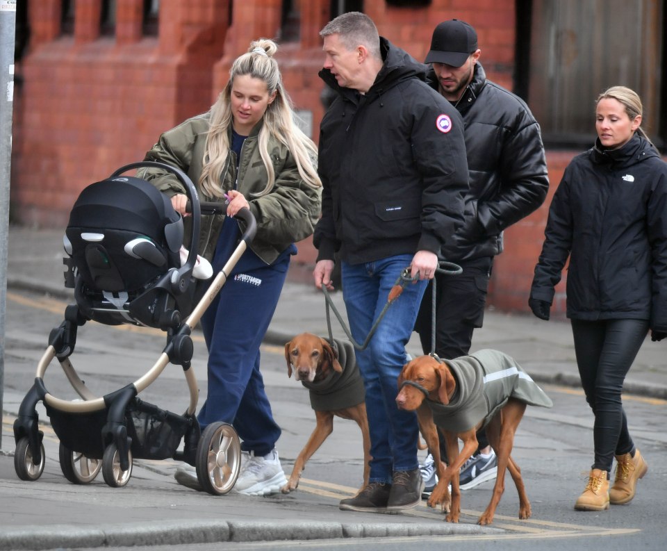 Molly-Mae could be seen pushing baby Bambi's pram as she wore white trainers, navy tracksuit bottoms and a khaki green jacket