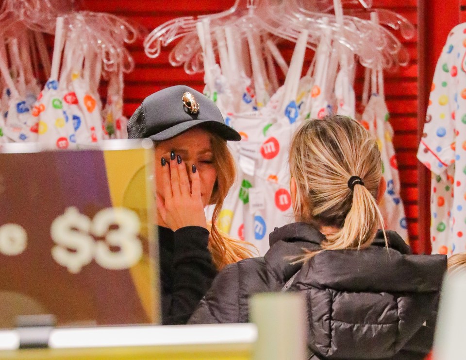 The singer, wearing a baseball cap, tried to hide her face