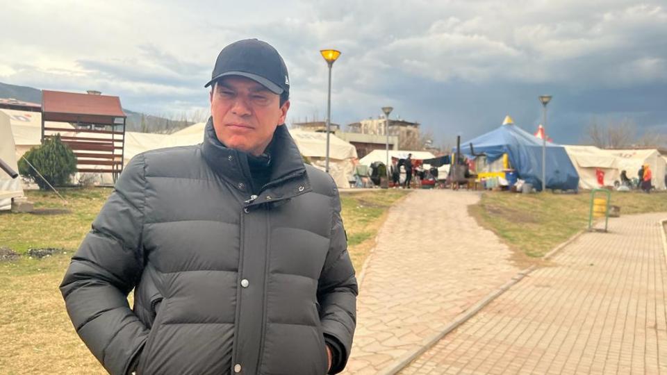 Tamer in front of makeshift camps in Nurdagi