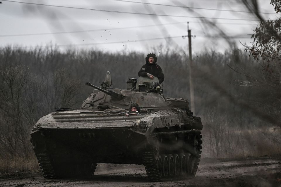 Ukrainian servicemen on a BMP-2 tank drive towards the city of Bakhmut