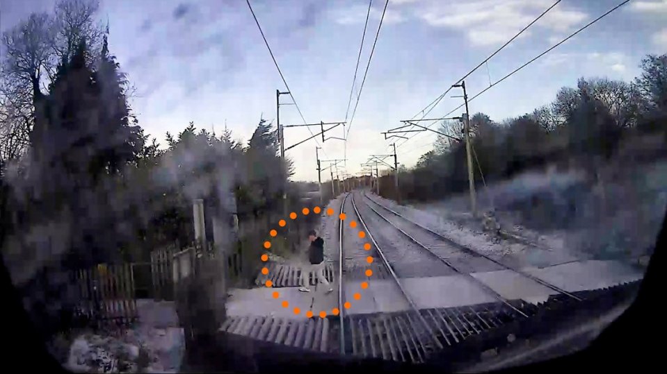 This is the heart-stopping moment a man walks across the tracks while a train is hurtling towards him