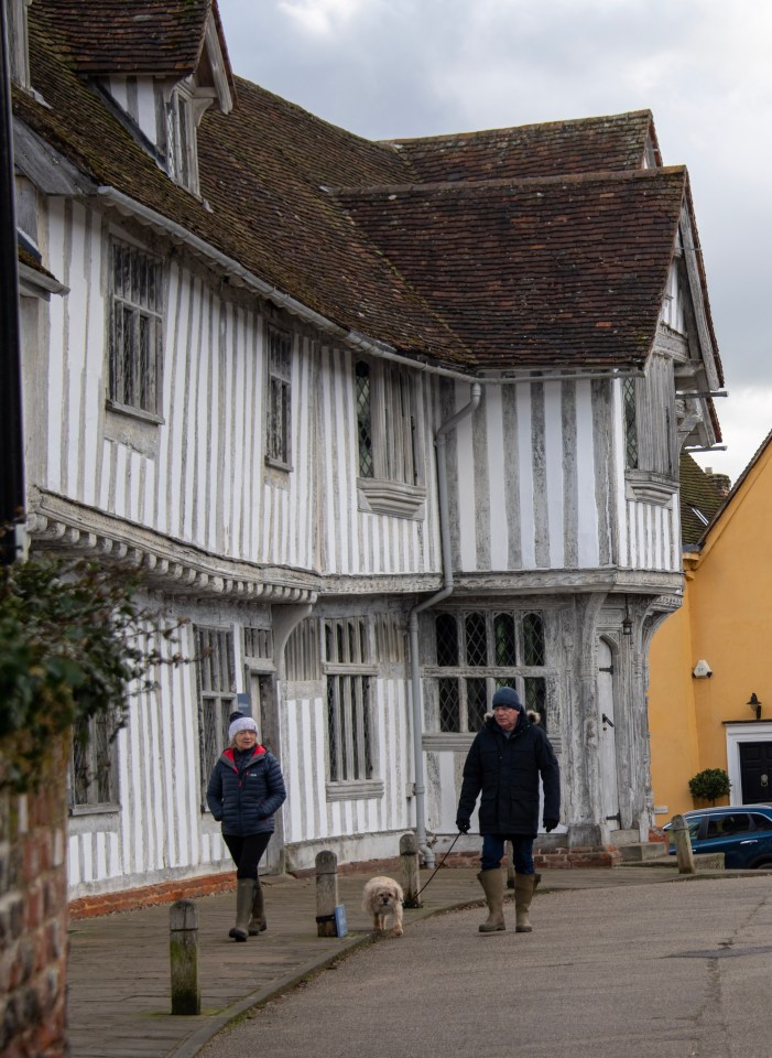 A couple walking their dog through the picturesque village