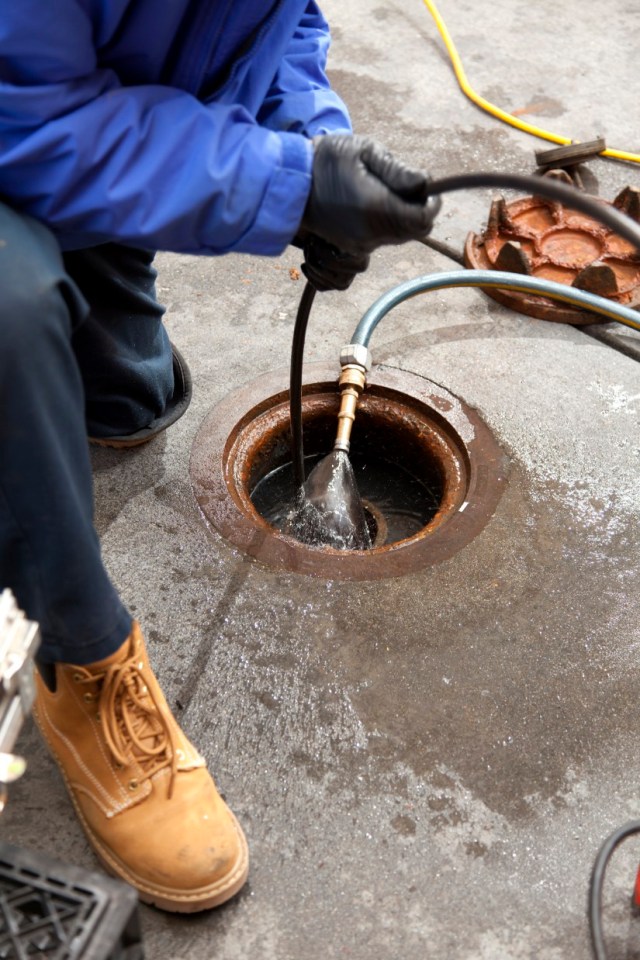 Commercial plumbers check a pipe using a camera after hydro line jetting the pipe at a large restaurant.