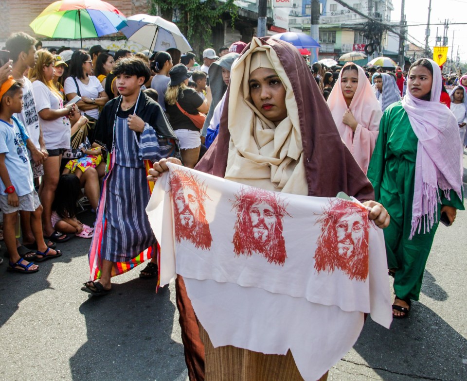 In the Philippines, a woman walks with Jesus' face on a cloth