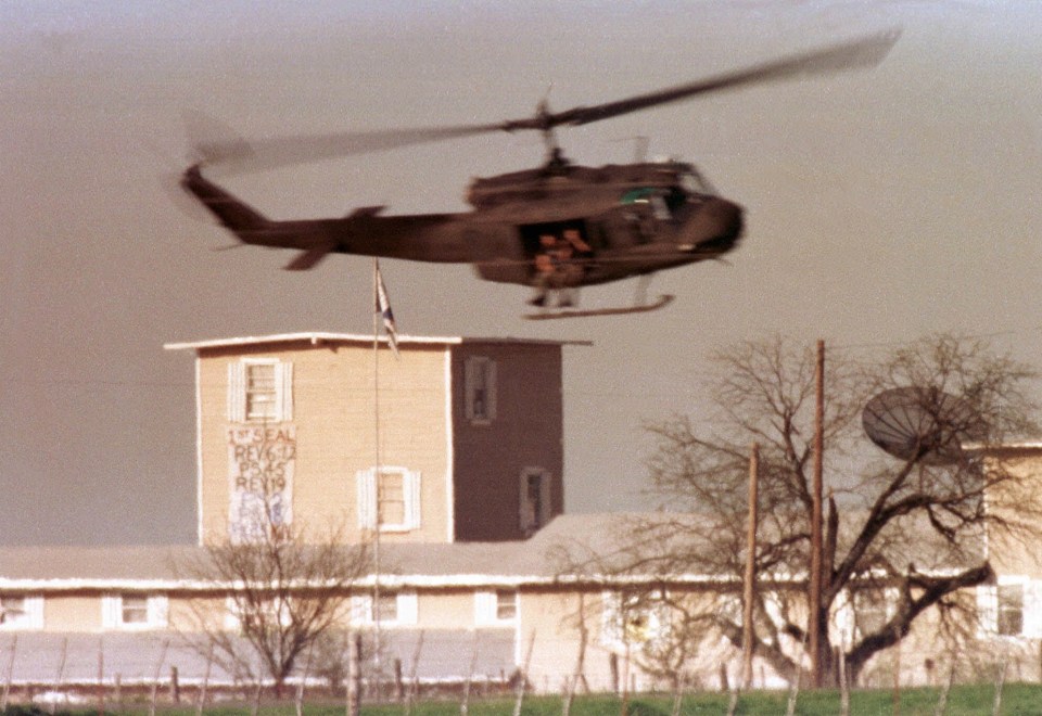 A helicopter flies over the commune headquarters