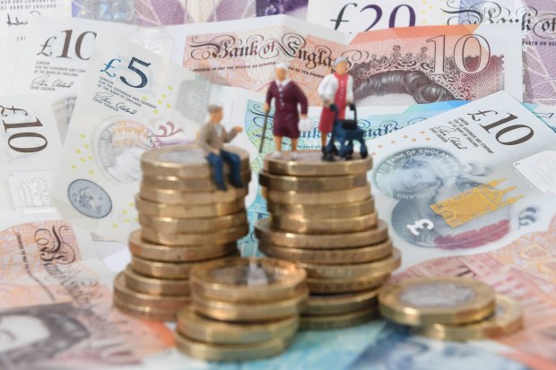 a stack of coins sits on top of a pile of bank of england notes