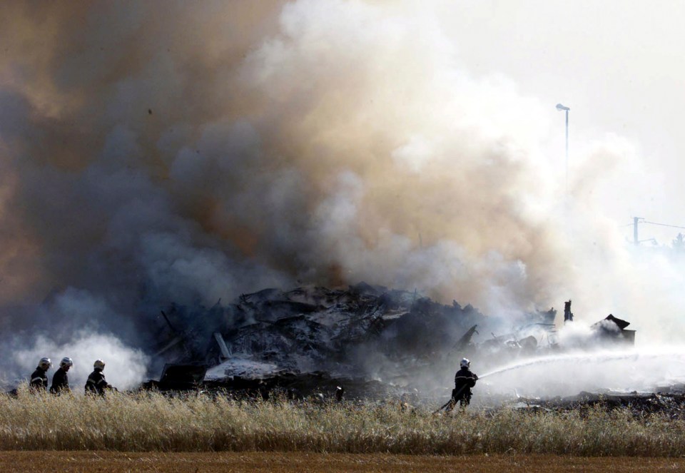 Firemen extinguishing the flames from the burning wreckage