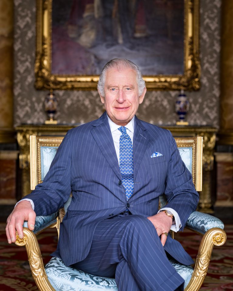 Charles was pictured sitting in front of a portrait of King George V