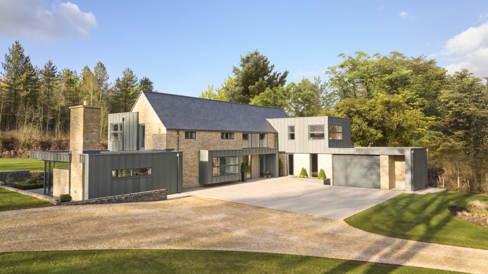 A dramatic gravel driveway leads through the perfectly landscaped front garden to the double garage