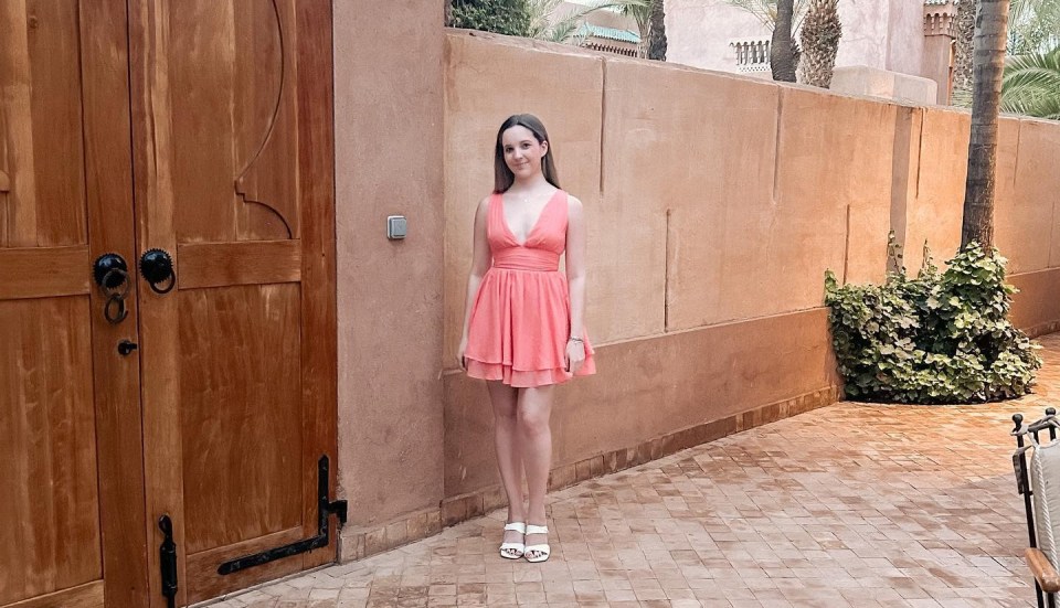 The 20-year-old looks stunning in a coral dress on holiday