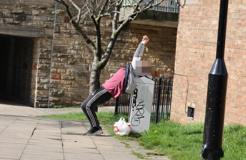 A man falls backwards onto the meter box