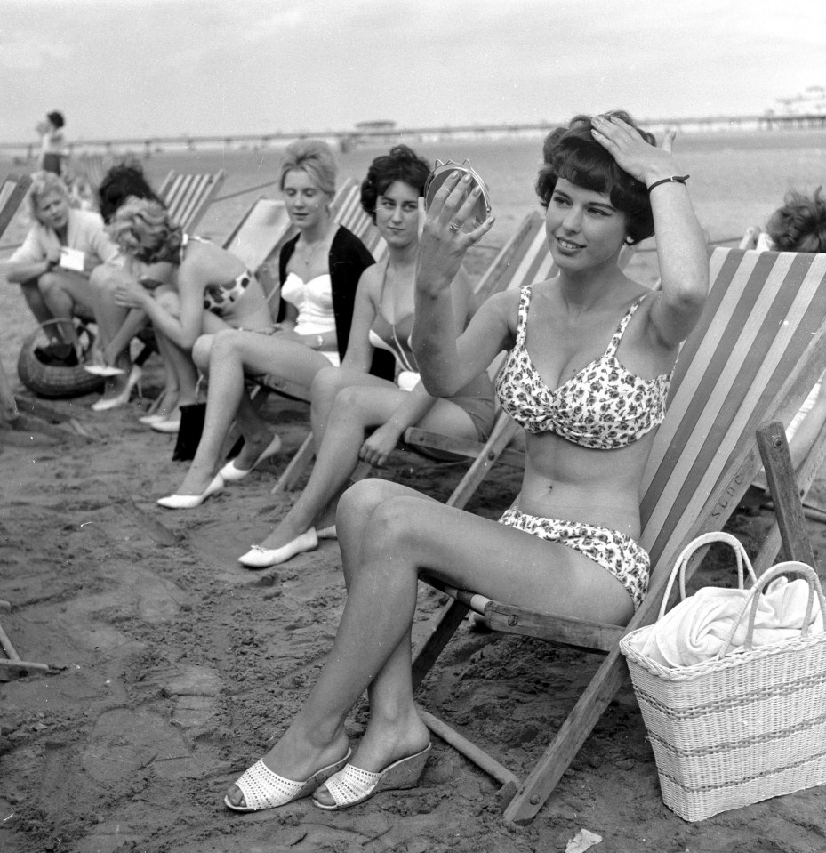 Beauty contest girls sitting in deck-chairs on the beach at Skegness putting on their make-up before the competition in 1960