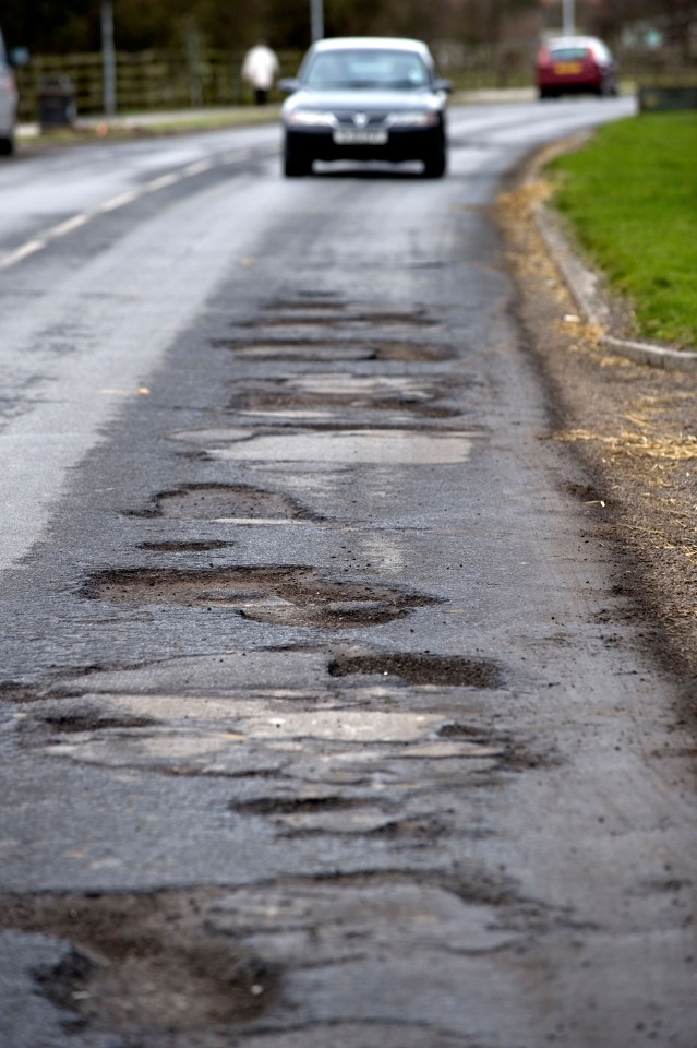 A car approaches potholes in Priory Road, Hull, East Yorkshire