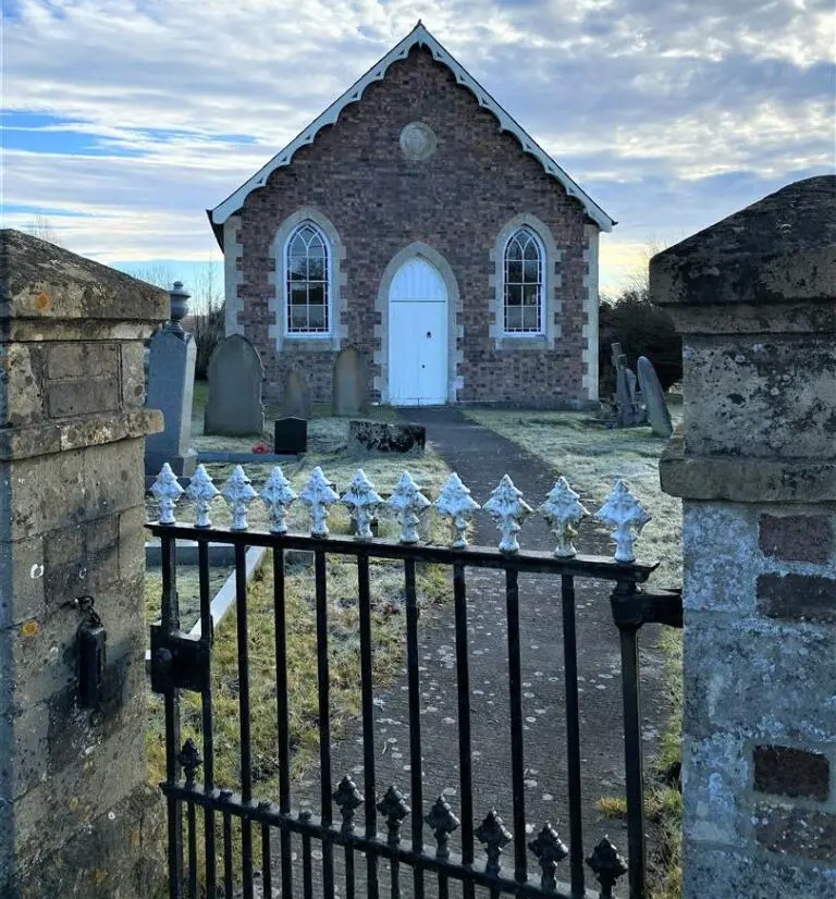 The church includes rows of graves in the front and back garden