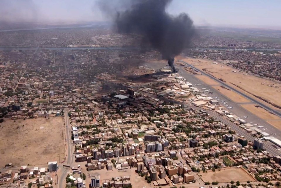 A smoke plume from an explosion covers the city