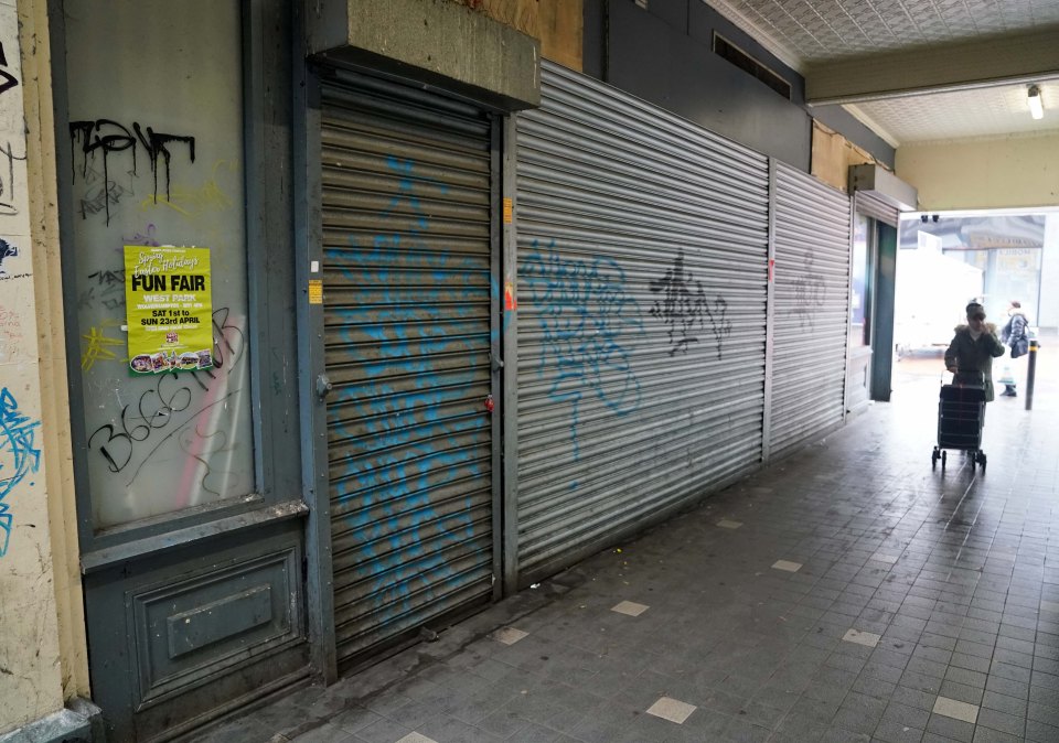 The alleyway by his shop is covered in graffiti and has multiple empty shops