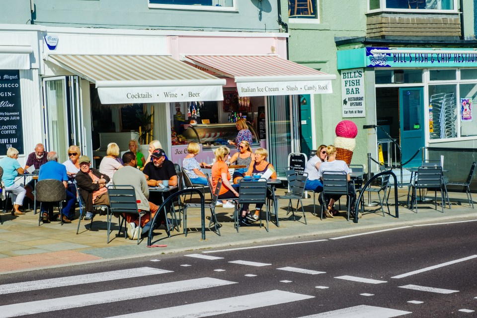 Customers sitting in the sun at a cafe in North Shields, England