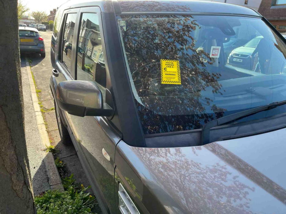 The yellow stickers appear to be standard parking fines, but actually contain insulting messages