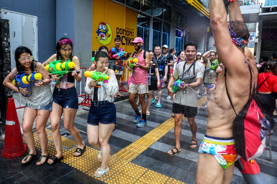 Residents and tourists take to the streets to spray each other with cold water