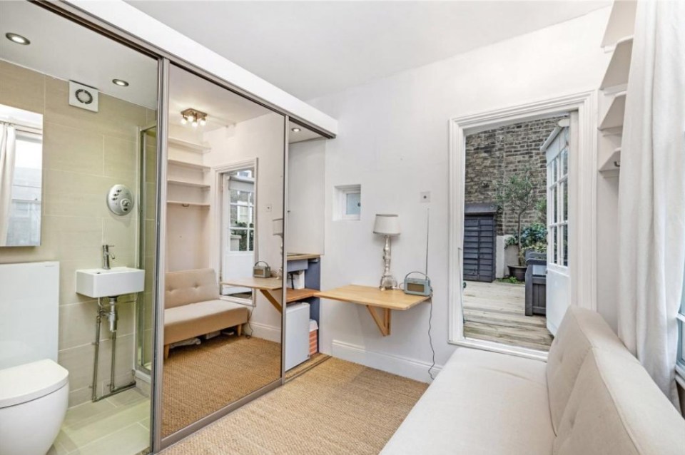 A mirror sat opposite the bed reveals a bathroom and kitchen area when slid either side