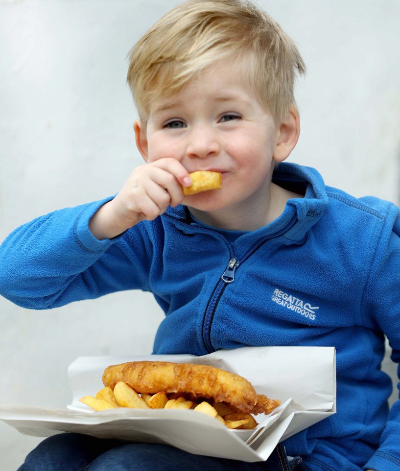 Little Auben tucks into his friend's feast in England's fish and chip capital