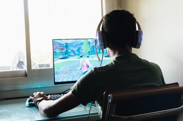 a man wearing headphones is playing a video game on a computer