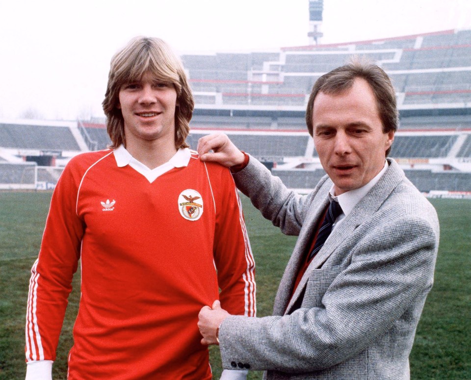 a man in a red adidas shirt stands next to another man