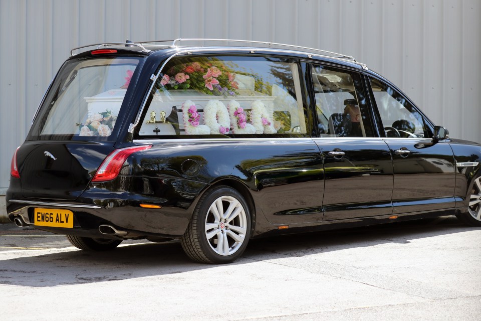 The hearse carried a white coffin and beautiful flowers