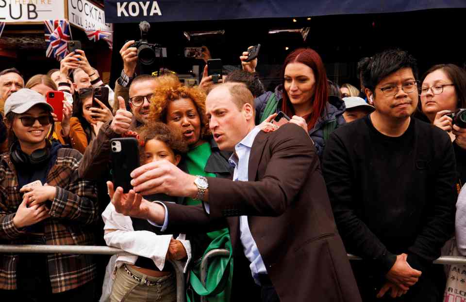 William joined in, holding phones belonging to members' of the public and posing for pictures