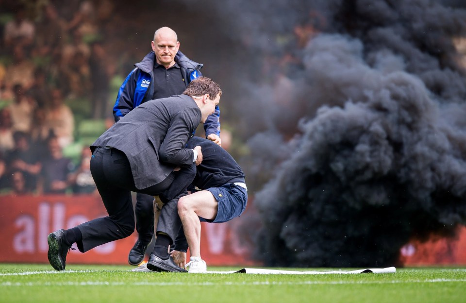 Smoke bombs were thrown onto the pitch, while fans also ran on to the field of play