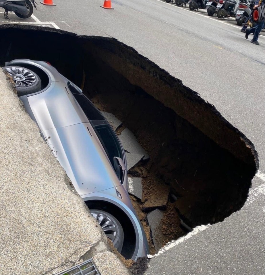 This is the shocking moment a sinkhole swallows a Tesla Model Y - with the rest of the street left completely untouched