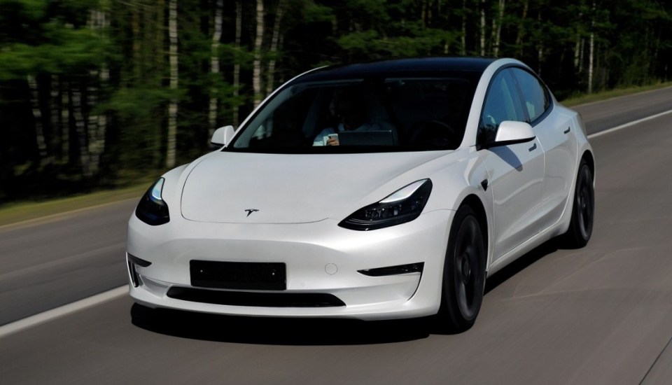 Minsk, Belarus - April 15, 2021: Tesla Model 3 Performance 2021 MY drives on a highway. It has dual-motor all-wheel drive, total output is 451 hp. Model 3 is the best-selling plug-in electric vehicle.