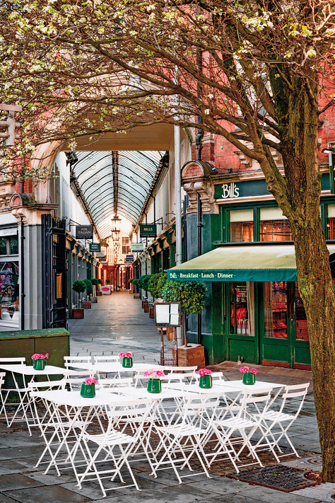 EE0T3J Tables and chairs outside the entrance to Wyndham Arcade.