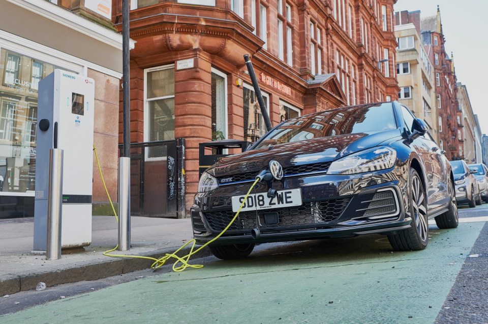 MK45KT Volkswagen Golf electric car being charged on street. Bothwell Street Glasgow Scotland