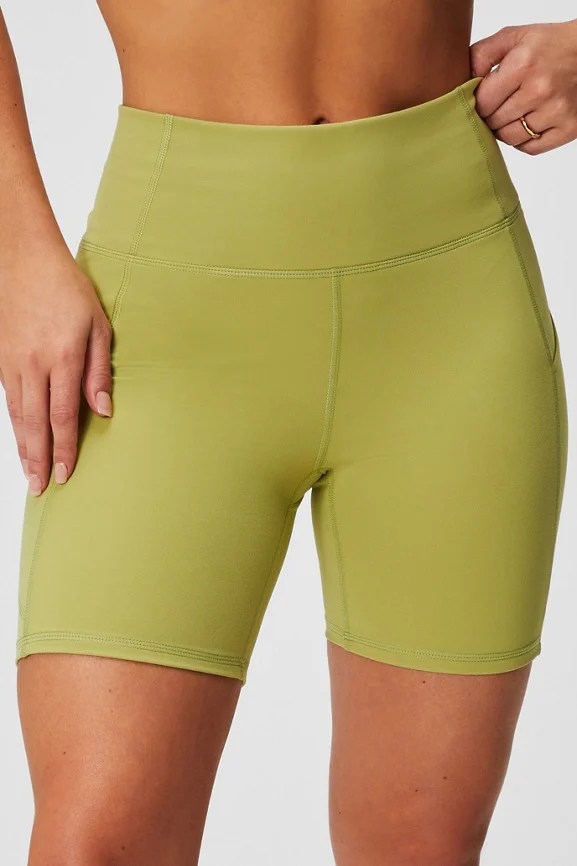 Olive green biker shorts with pockets.