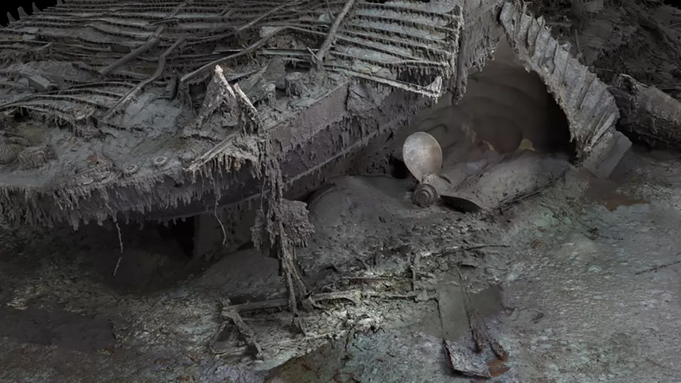 A giant propeller sitting in the ocean mud