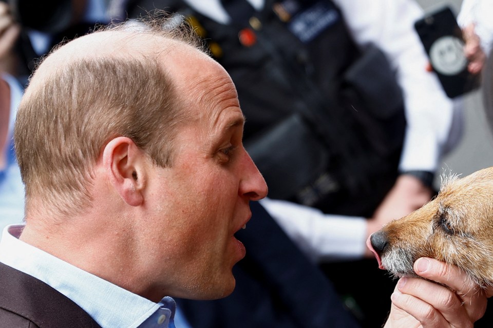 William pets a fan's dog, called Rigby, as he greets people after visiting The Dog and Duck Pub