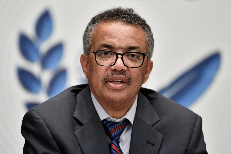 a man wearing glasses and a suit stands in front of a wheat symbol